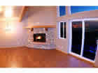 living room with river rock fireplace and city light views.